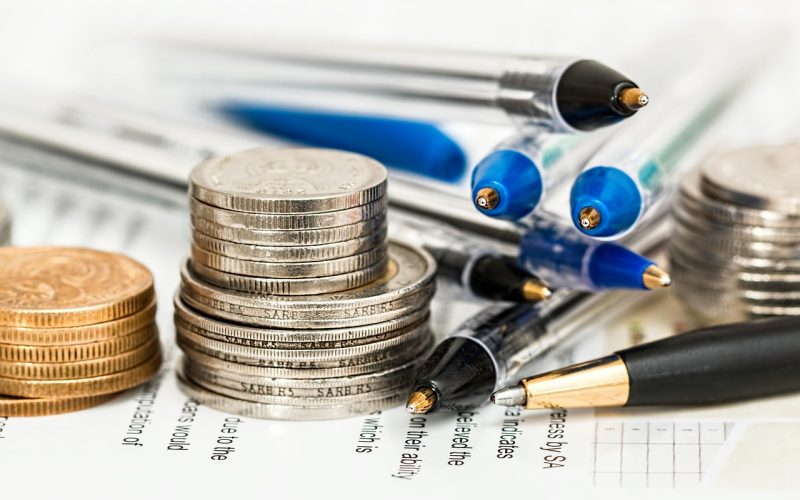 银行柜台内一根根封装好的投资金条整齐码放在保险柜托盘上，金属光泽冷峻，背景是防弹玻璃后的营业厅